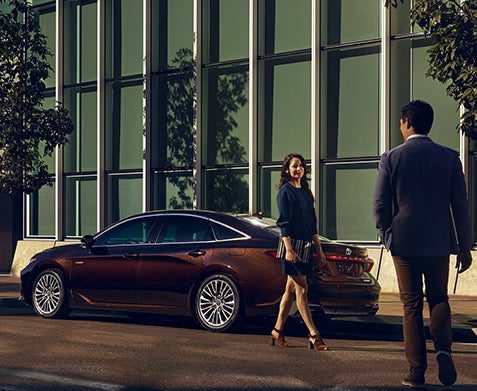 image of a woman walking beside a car and a man meeting her