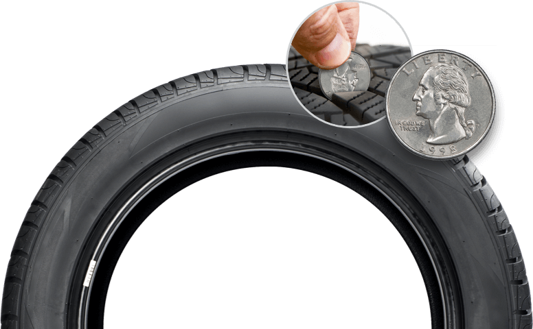 image of a tire with someone holding a quarter to check the tread